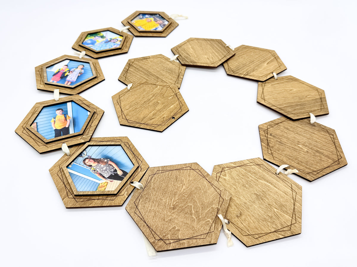 Hexagonal wooden photo garland with blank and printed photo panels, displayed on a white background.